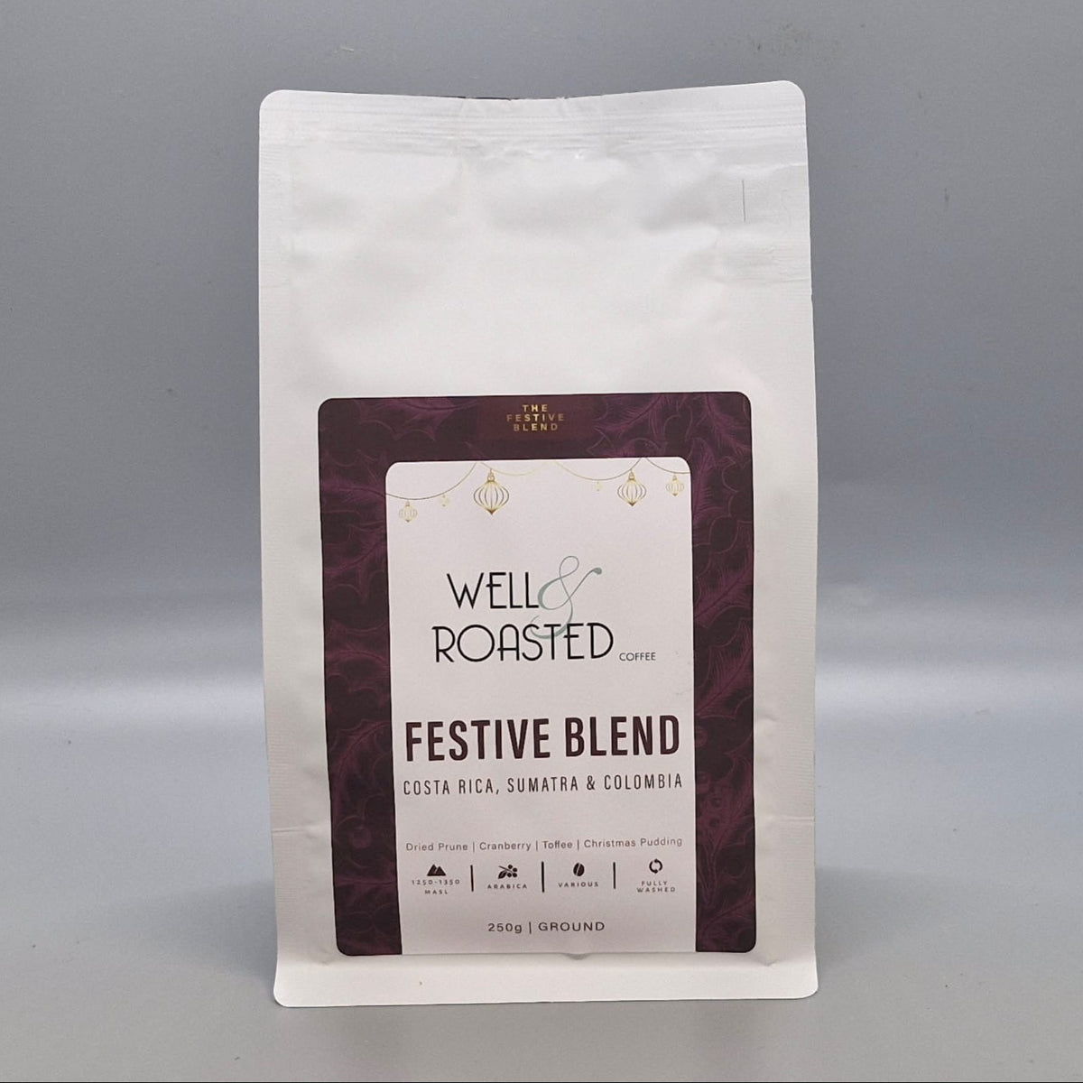 Well Roasted Coffee Festive blend 2026, a 250g white bag of ground coffee with a festive label. A blend of Costa Rica, Sumatra and Colombia speciality coffees.